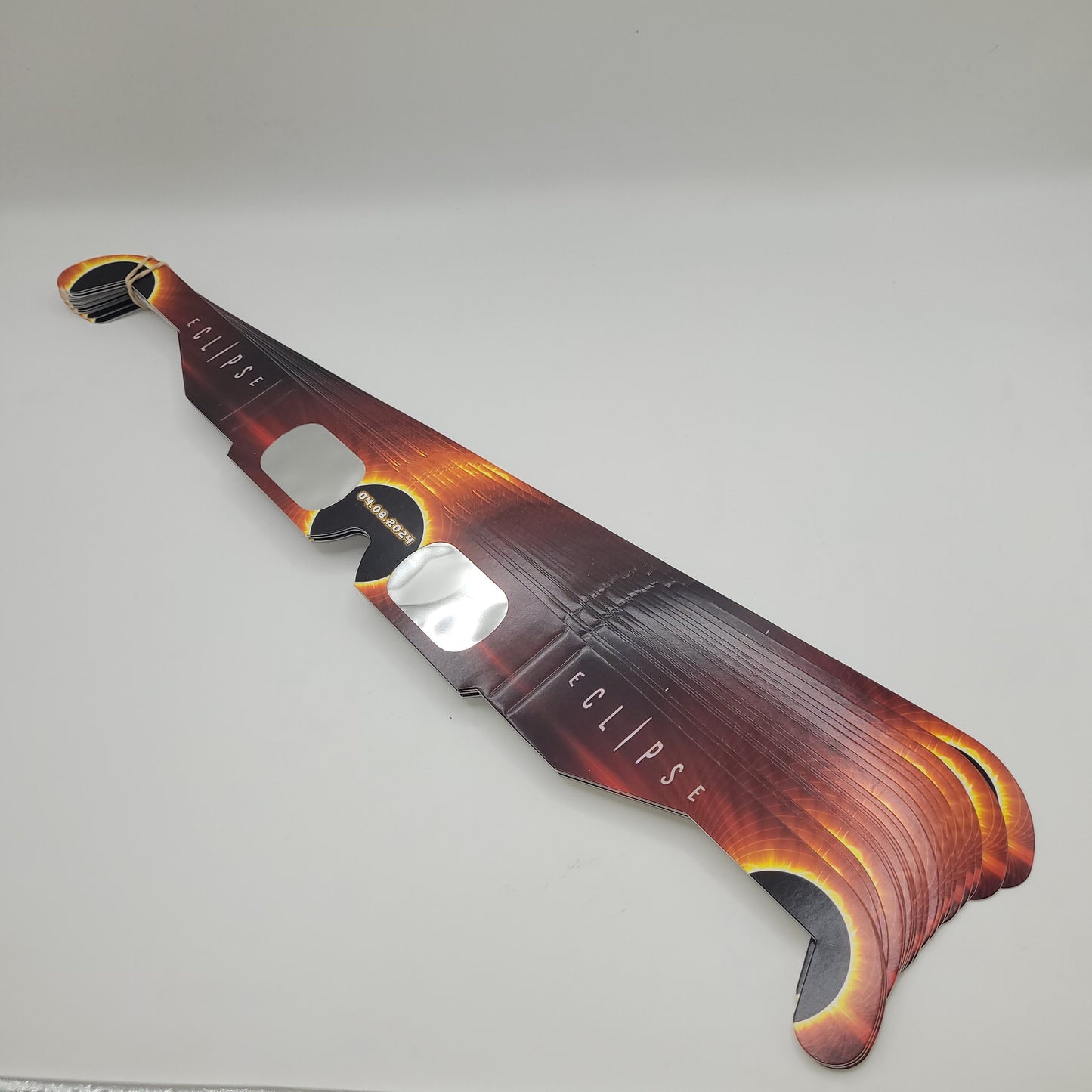 A stack of orange solar eclipse glasses in bulk.